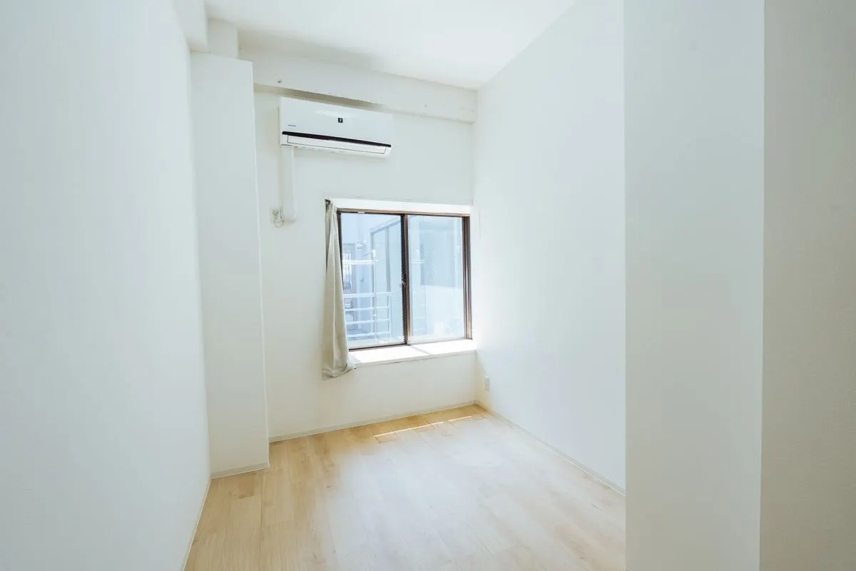 家具のない白い部屋。窓から光が入る。