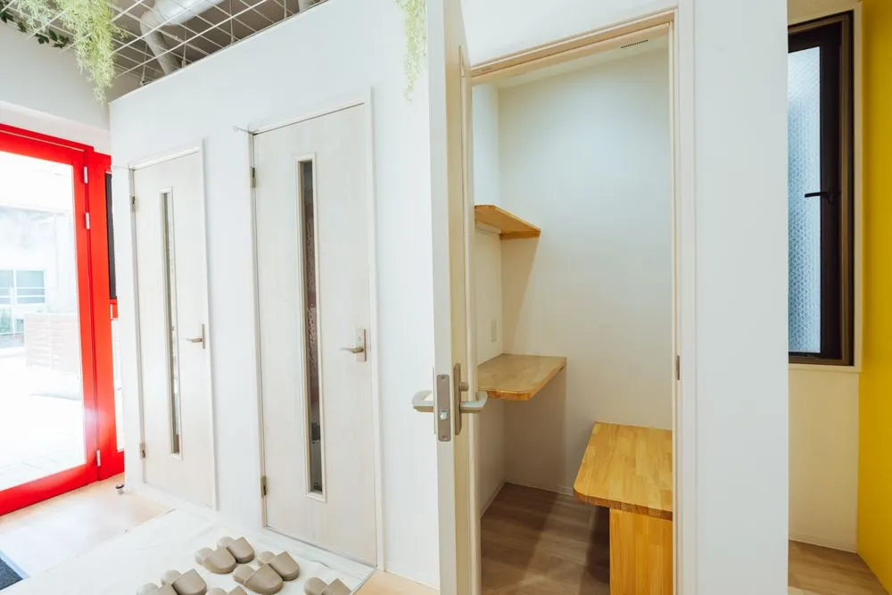 開いた扉の奥に、木のデスクとベンチがある小部屋